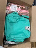 Box showing teal backpack and packaged pink sticks