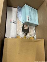 Top view of box showing white boxes, magazine/book, light blue box