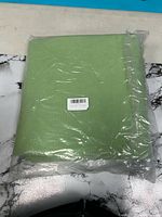 Folded green ribbed mat in plastic wrap