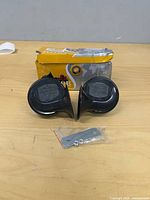Two black horns, box, mounting hardware visible