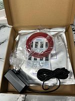 Boxed pool light kit showing gasket, manual, power adapter
