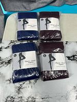 Four sealed packs of fleece-lined tights, navy and burgundy