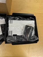 Right box showing second white tray and black insert in plastic wrap