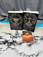 Two Zodiac Academy novels, Wild Whispers Oracle deck box sealed, silver figurine on tabletop