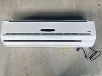 Full front view of Aermec wall-mounted fan coil showing louvers and power cord