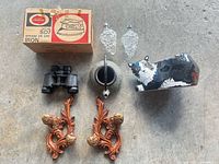 All items laid out: boxed iron, two glass grape ornaments, cast iron teapot, cat puzzle box, binoculars, pair of resin wall sconces