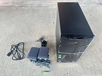 Full view of HP tower, power cord, two speakers and adapter