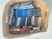 Cardboard box containing Sony player, remote and rows of Blu-ray, DVD, jewel cases and Sopranos box sets