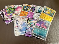 Group of roughly 14 Chinese-language Pokémon cards spread on surface, showing variety and condition