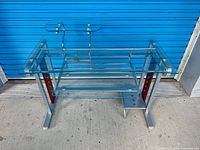 Full view of glass computer desk showing top, keyboard tray, monitor shelf, frame