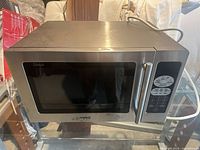 Front view of Sanyo stainless steel microwave oven showing door, handle and keypad