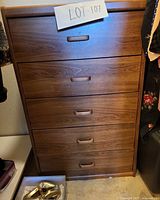 Front view of five-drawer chest showing recessed wooden pulls and overall finish