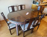 full view of oval dining table with six chairs and glass top