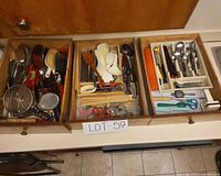 Three drawer dividers containing assorted utensils and cutlery