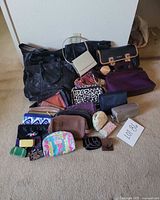 Group shot of all handbags, purses and wallets on floor