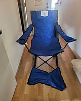 Full view of blue folding camping chair set up with footrest extended