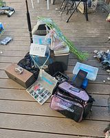 Group shot of entire fishing lot including bags, boxes, rod, cooler, net