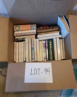 Box of uniform white-spine Chinese paperbacks with several larger Chinese hardcovers