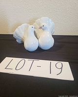 Front view of both glossy white Lladro fan-tail bird figurines