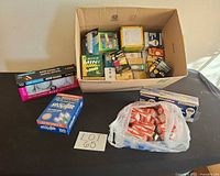 Overview of lot showing cardboard box of assorted bulb packs plus additional boxes and bag of red-boxed bulbs