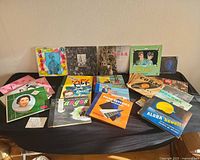 Overall lot of 20+ assorted vinyl record sleeves displayed on table