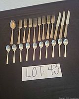 Full lot layout showing 22 pieces of flatware on dark surface