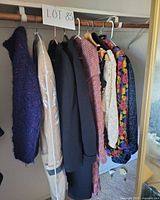 Full view of nine garments hanging on rod