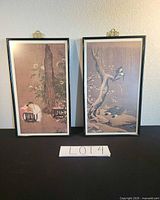 Both framed prints side by side on black surface