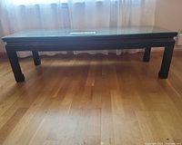 Full view of rectangular rosewood coffee table with glass top