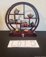 Full view of circular shelf with all eight teapots displayed