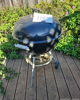 Full view of Weber kettle grill with lot tag, tools staged inside