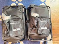 two black folding backpack chairs front view with logo