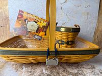 Rectangular Renewal basket with swing handle, green & blue trim, pewter tie-on in foreground; Spring Meadow basket visible behind