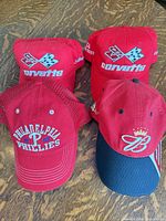 Front view of all four caps showing logos and colors