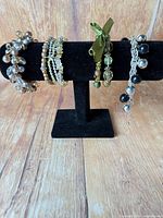 Four bracelets displayed on black T-bar stand