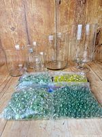 All five glass vessels with four bags of glass gems