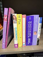 All eight books standing on shelf showing spines