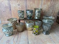 All eleven mercury glass candle holders arranged on wood backdrop