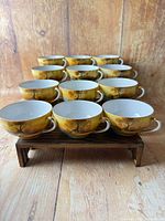 Twelve Tree in the Meadow cups arranged on wooden stand