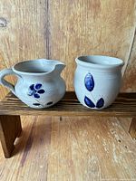 Overall view of both salt-glazed pieces on a wooden riser