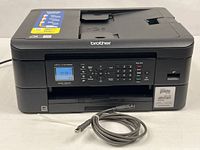 Front view of Brother MFC-J1010DW printer with USB cable