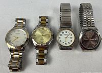 Front view of four wristwatches side by side on white background