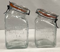 Both jars front view showing embossed brand and wire clamp lids