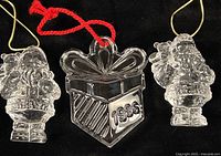 Front view of three crystal ornaments – two Santas, one gift dated 1996