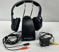 Front view of headphones on transmitter with cables and power adapter