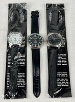 Three wristwatches, two packaged, one open