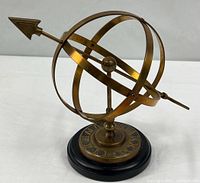 Full view of brass armillary sphere on black base