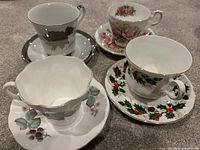 Four bone china cup and saucer sets upright