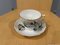 teacup on saucer showing floral design and gold trim