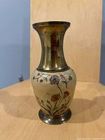 Full view of brass vase front showing floral painting and patina
